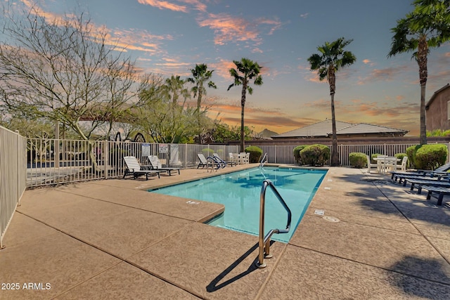 community pool with a patio and fence