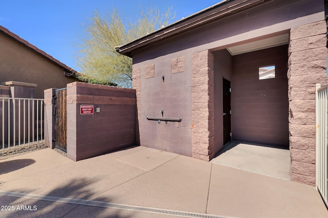 view of exterior entry featuring a gate and fence