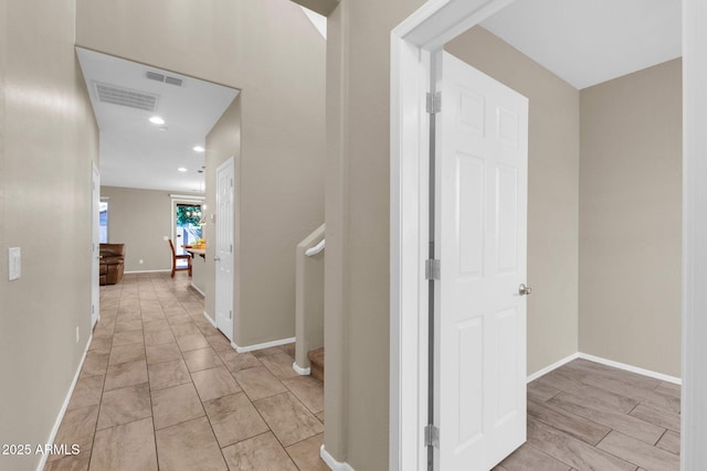 corridor featuring baseboards and visible vents