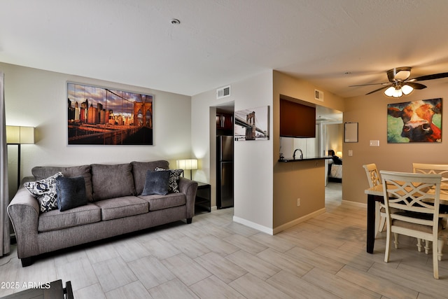 12123 W Bell Rd Unit 218, Surprise, AZ 85378 - living room featuring wood finish floors, visible vents, baseboards, and a ceiling fan