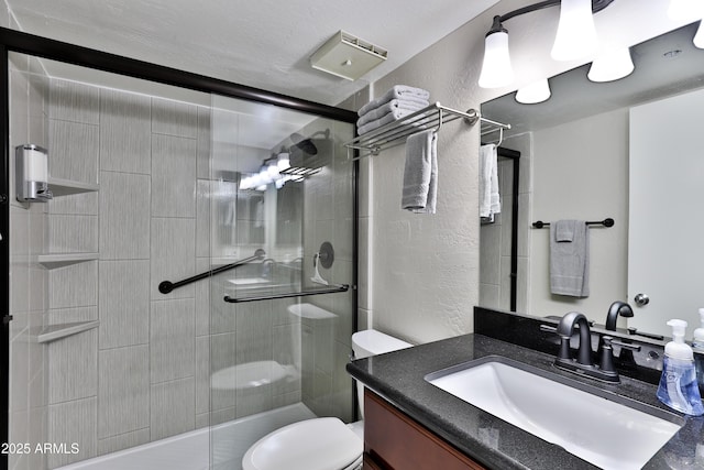 12123 W Bell Rd Unit 218, Surprise, AZ 85378 - bathroom with vanity, a shower stall, toilet, and a textured wall