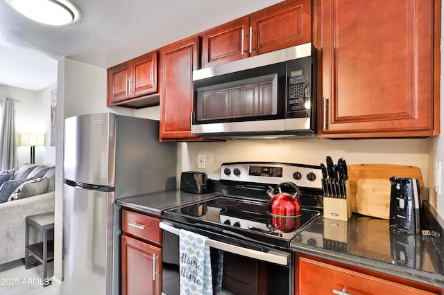 12123 W Bell Rd Unit 218, Surprise, AZ 85378 - kitchen featuring dark stone countertops, dark brown cabinets, open floor plan, and stainless steel appliances