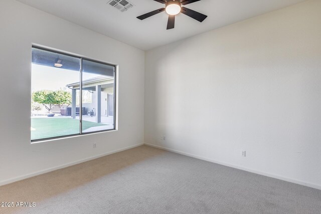 empty room with carpet, visible vents, ceiling fan, and baseboards