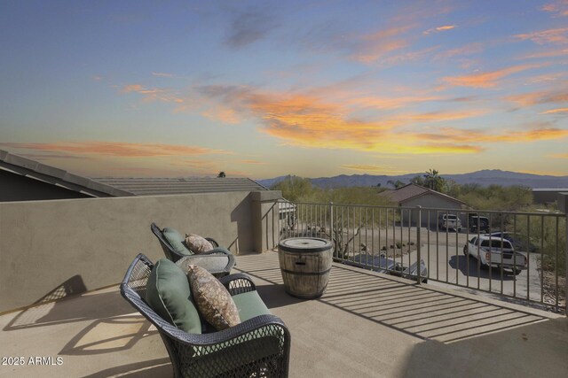 patio terrace at dusk with a mountain view and a balcony