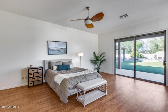 bedroom with wood finished floors, a ceiling fan, visible vents, baseboards, and access to outside