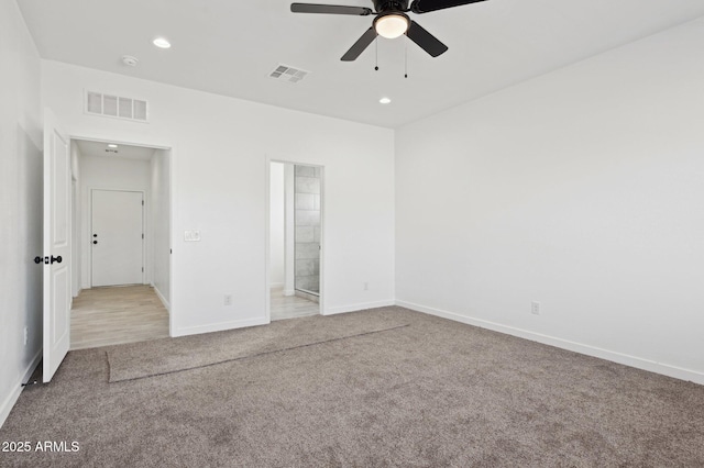 unfurnished bedroom featuring ensuite bathroom, light colored carpet, and ceiling fan