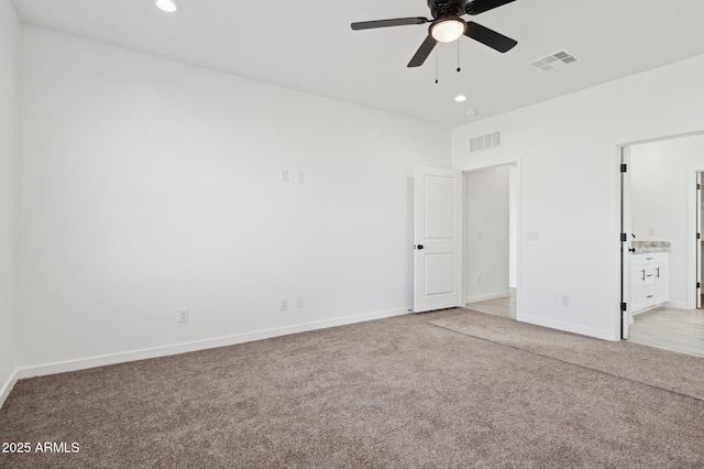 unfurnished bedroom featuring ceiling fan, ensuite bathroom, and light colored carpet