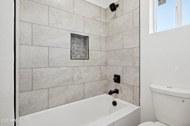 bathroom featuring toilet and tiled shower / bath combo