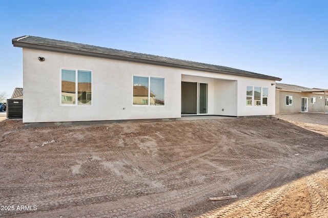 rear view of property with central AC