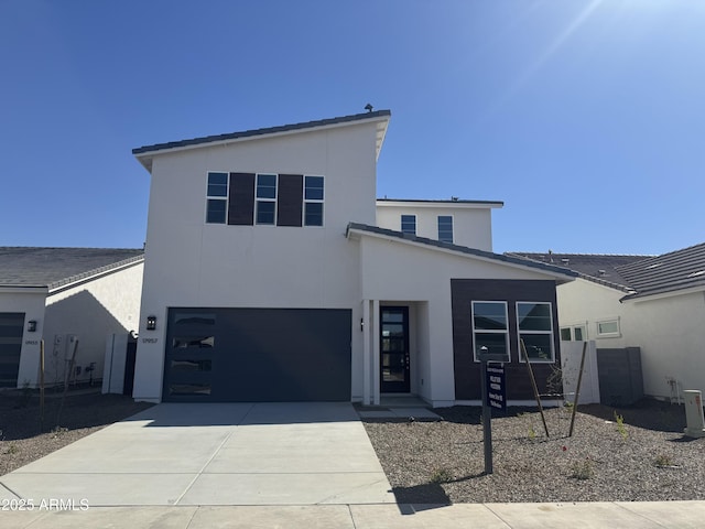 contemporary house featuring stucco siding, an attached garage, and concrete driveway