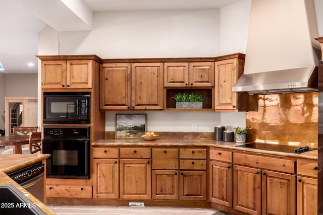 kitchen featuring black appliances, sink, decorative backsplash, and wall chimney range hood