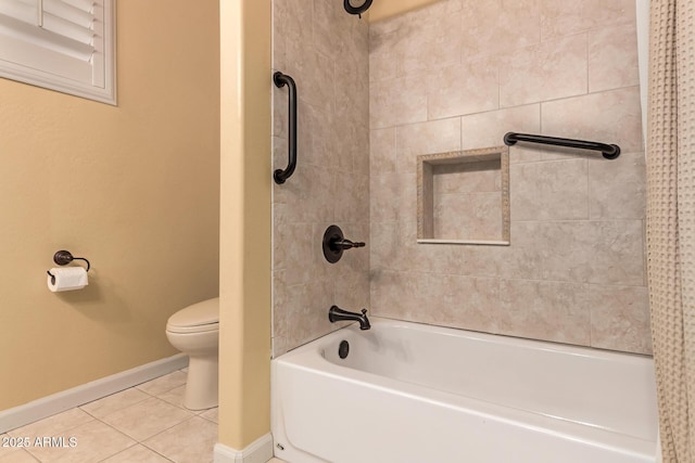 bathroom with tile patterned flooring, tiled shower / bath combo, and toilet