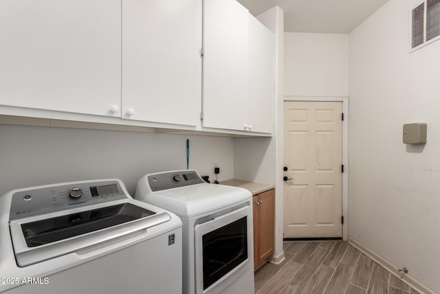 washroom featuring independent washer and dryer and cabinets