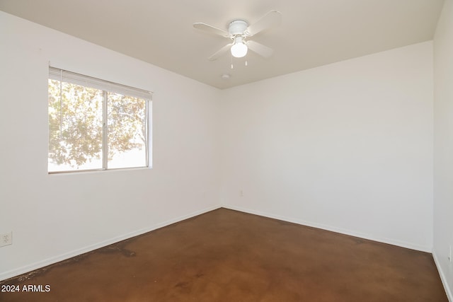 empty room with ceiling fan and dark carpet