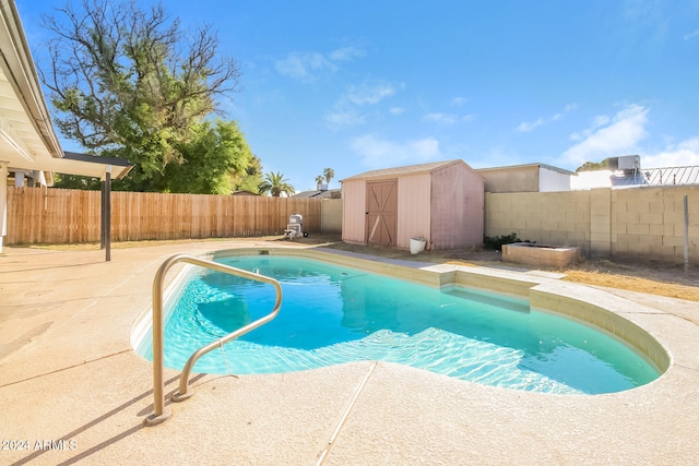 view of pool with a patio and a storage unit