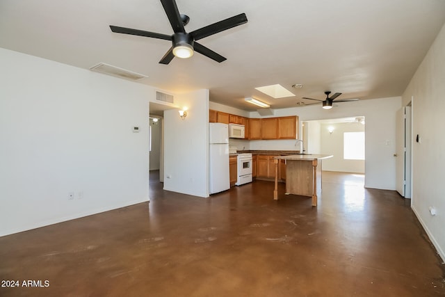 kitchen featuring a skylight, sink, and white appliances