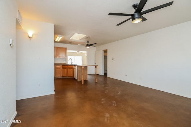 unfurnished living room featuring sink and a skylight