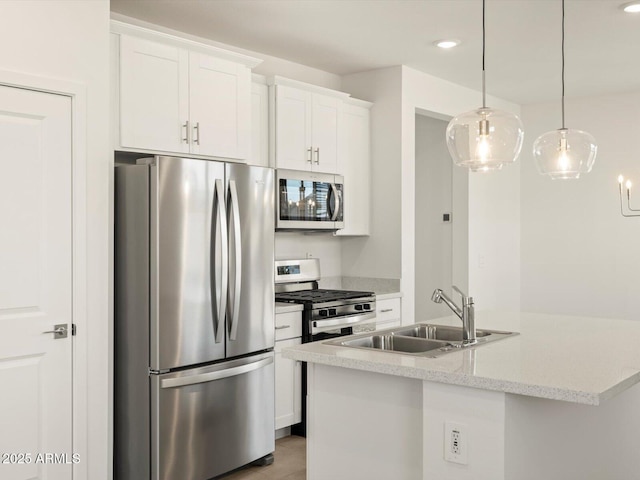 kitchen with white cabinetry, appliances with stainless steel finishes, decorative light fixtures, and sink