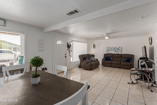 dining room with ceiling fan, beamed ceiling, light tile patterned floors, and a textured ceiling