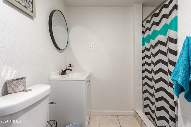 bathroom with tile patterned floors, toilet, vanity, and curtained shower