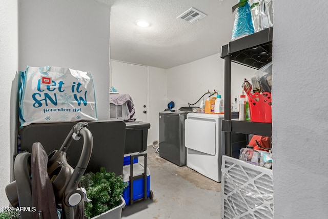 laundry area with a textured ceiling and washer and dryer