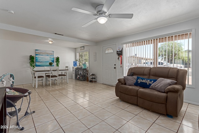 living room featuring ceiling fan, light tile patterned flooring, and a healthy amount of sunlight