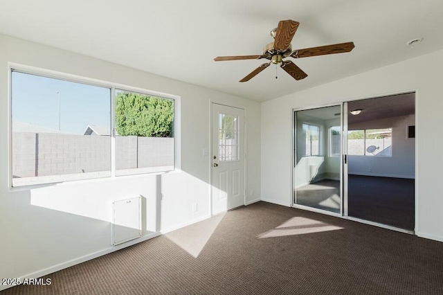 entryway with vaulted ceiling, ceiling fan, and dark carpet