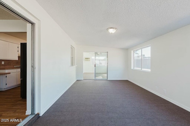 carpeted spare room featuring a textured ceiling