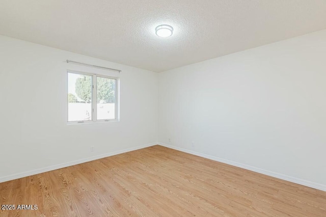 unfurnished room with light hardwood / wood-style floors and a textured ceiling