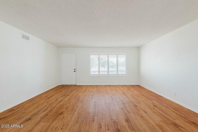 empty room featuring light hardwood / wood-style flooring and a textured ceiling