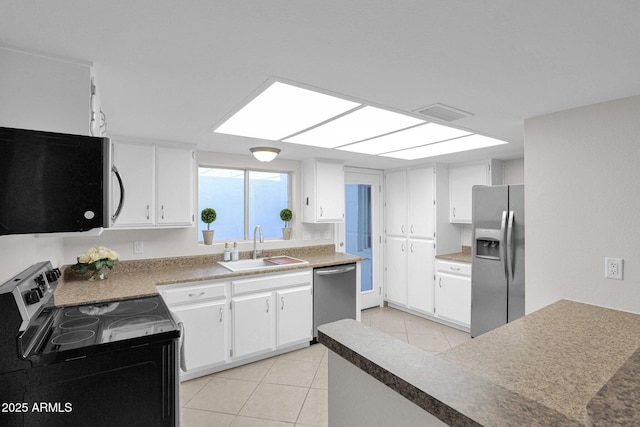 kitchen with light tile patterned floors, stainless steel appliances, a sink, visible vents, and white cabinetry