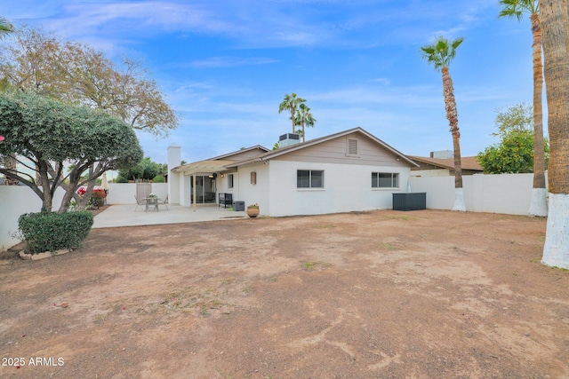 rear view of house with a patio, central AC unit, and a fenced backyard