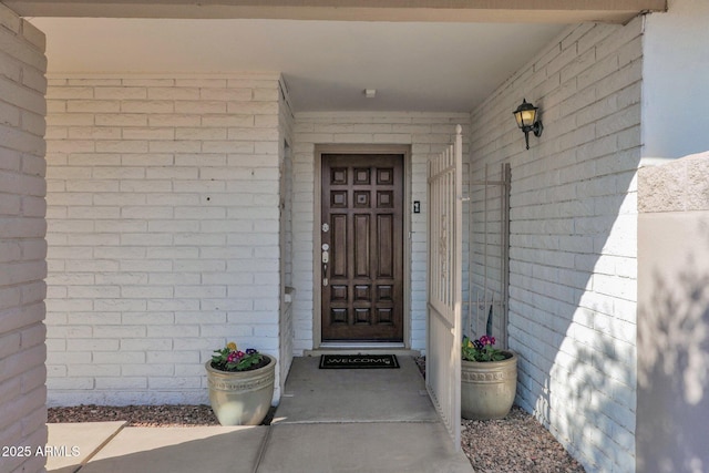 view of exterior entry with brick siding