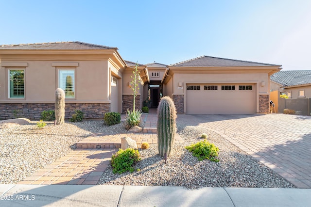 view of front of property with stucco siding, an attached garage, and stone siding