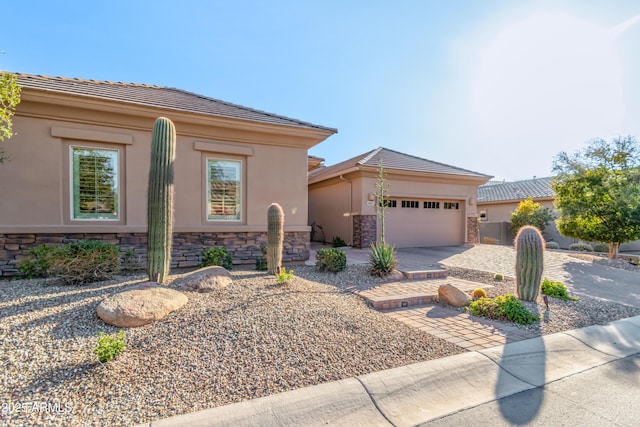 view of front of home with stucco siding, an attached garage, stone siding, and concrete driveway