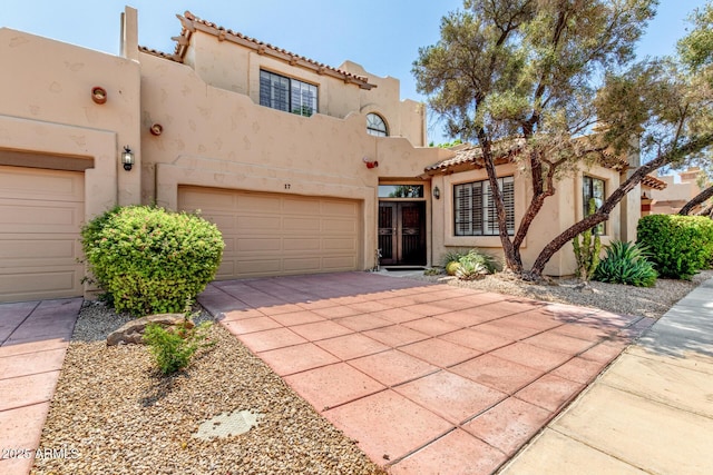 7955 E Chaparral Rd Unit 17, Scottsdale, AZ 85250 - view of front of house featuring stucco siding, driveway, a tiled roof, and an attached garage