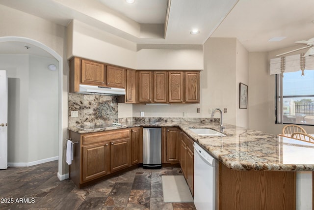 7955 E Chaparral Rd Unit 17, Scottsdale, AZ 85250 - kitchen featuring white dishwasher, under cabinet range hood, a peninsula, brown cabinetry, and black electric cooktop