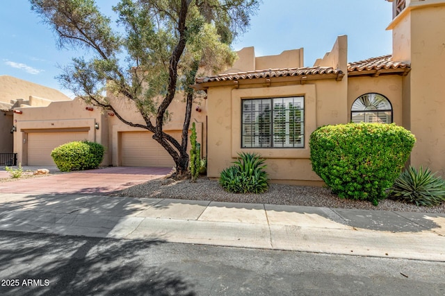 7955 E Chaparral Rd Unit 17, Scottsdale, AZ 85250 - view of front of property with an attached garage, decorative driveway, stucco siding, and a tile roof