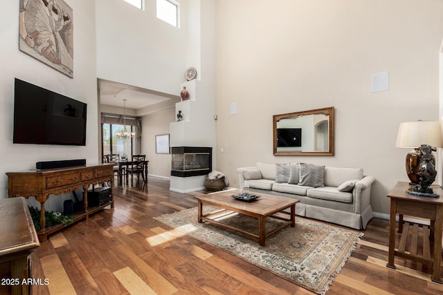 7955 E Chaparral Rd Unit 17, Scottsdale, AZ 85250 - living area with a high ceiling, wood finished floors, and a multi sided fireplace