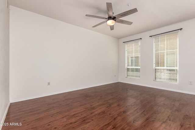 unfurnished room featuring dark wood-style flooring, baseboards, and ceiling fan