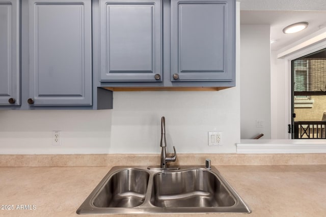 kitchen featuring a sink, gray cabinetry, and light countertops