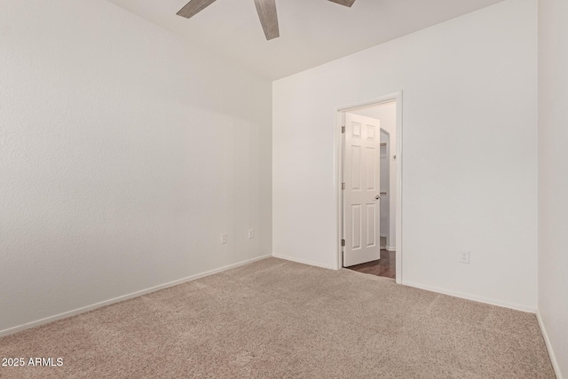 empty room featuring carpet, baseboards, and ceiling fan