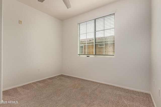 empty room with carpet flooring, baseboards, and a ceiling fan