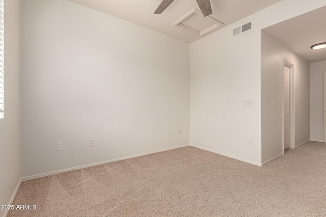 carpeted spare room with baseboards, attic access, and visible vents