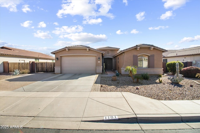 mediterranean / spanish home featuring driveway, an attached garage, a tiled roof, and stucco siding