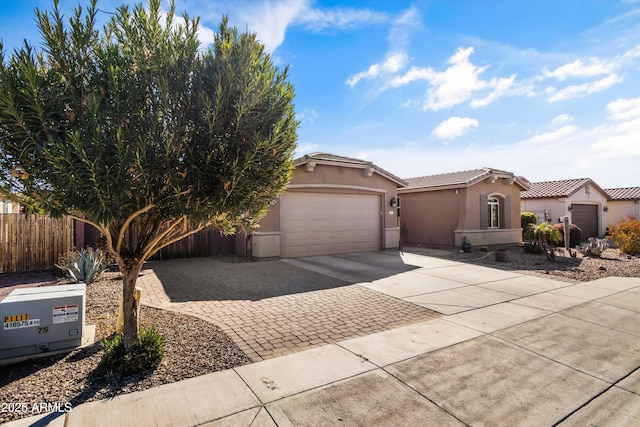 view of front of house with driveway, an attached garage, a tile roof, and stucco siding