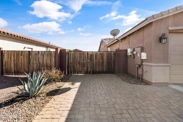 view of patio / terrace featuring a garage, a gate, and fence