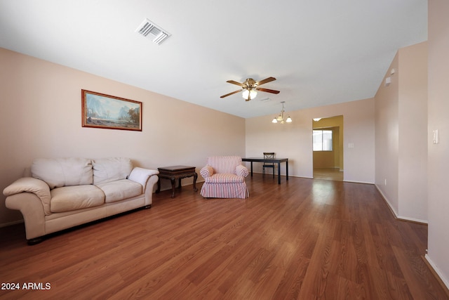 living room with dark hardwood / wood-style floors and ceiling fan with notable chandelier