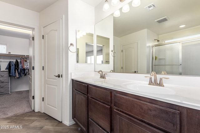 bathroom with visible vents, a sink, and a stall shower
