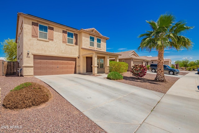 view of front of house with concrete driveway, stucco siding, fence, and a garage